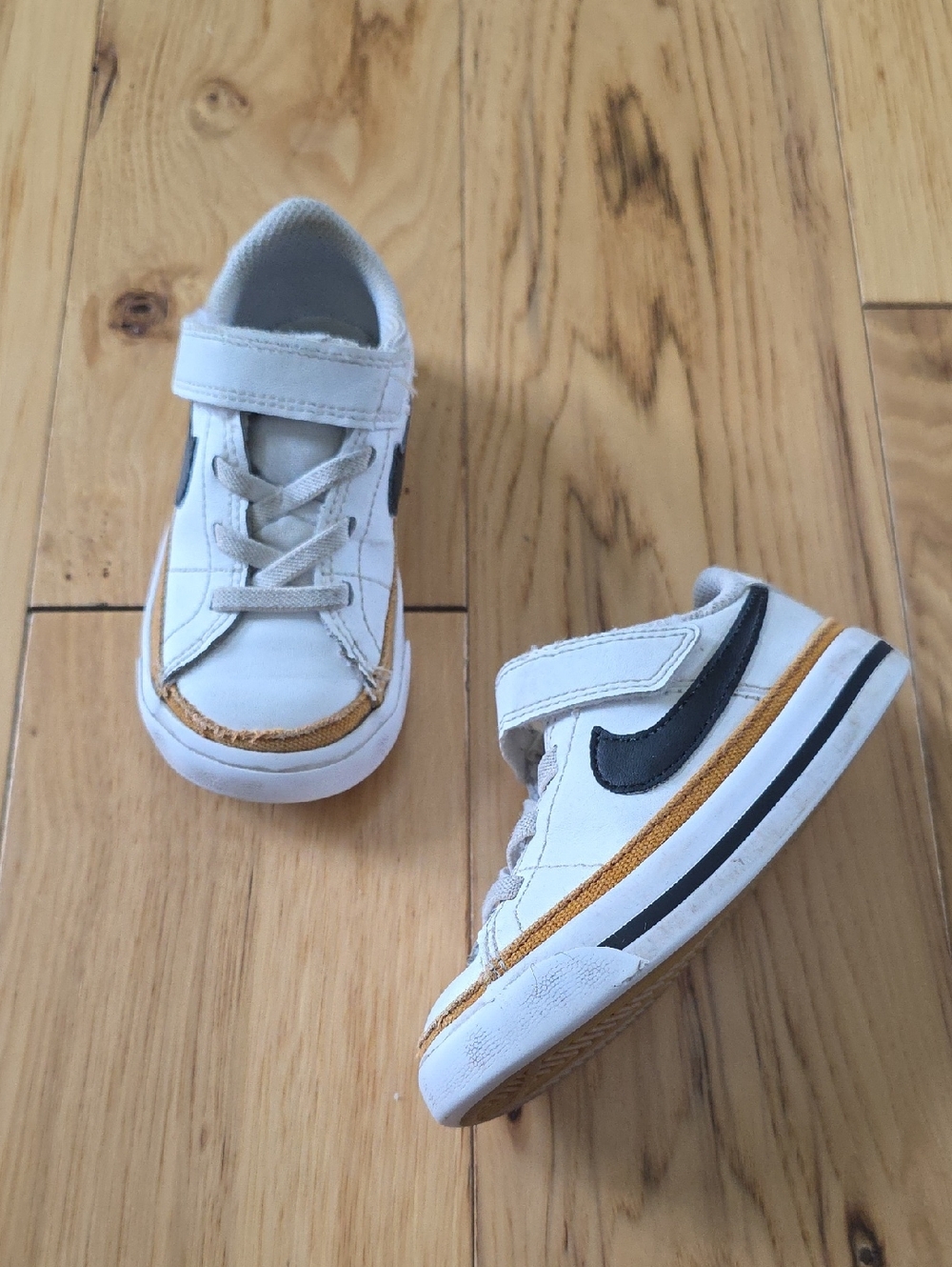Nike Kids White Sneakers with Black Swoosh and Gold Trim